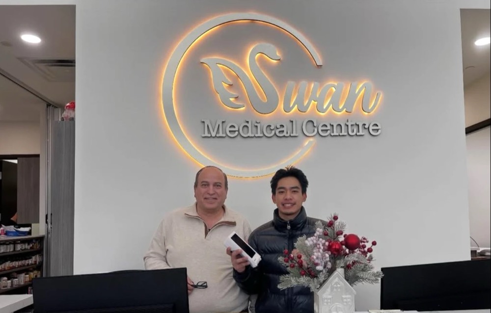 GT Payments rep with the owner of Swan Medical Centre at the front desk, holding their new Clover terminal